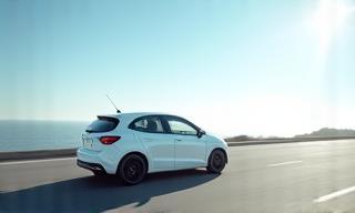 Auto compacto blanco en carretera soleada